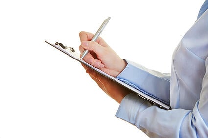 bigstock-Hand-holding-pen-and-checklist-48266159