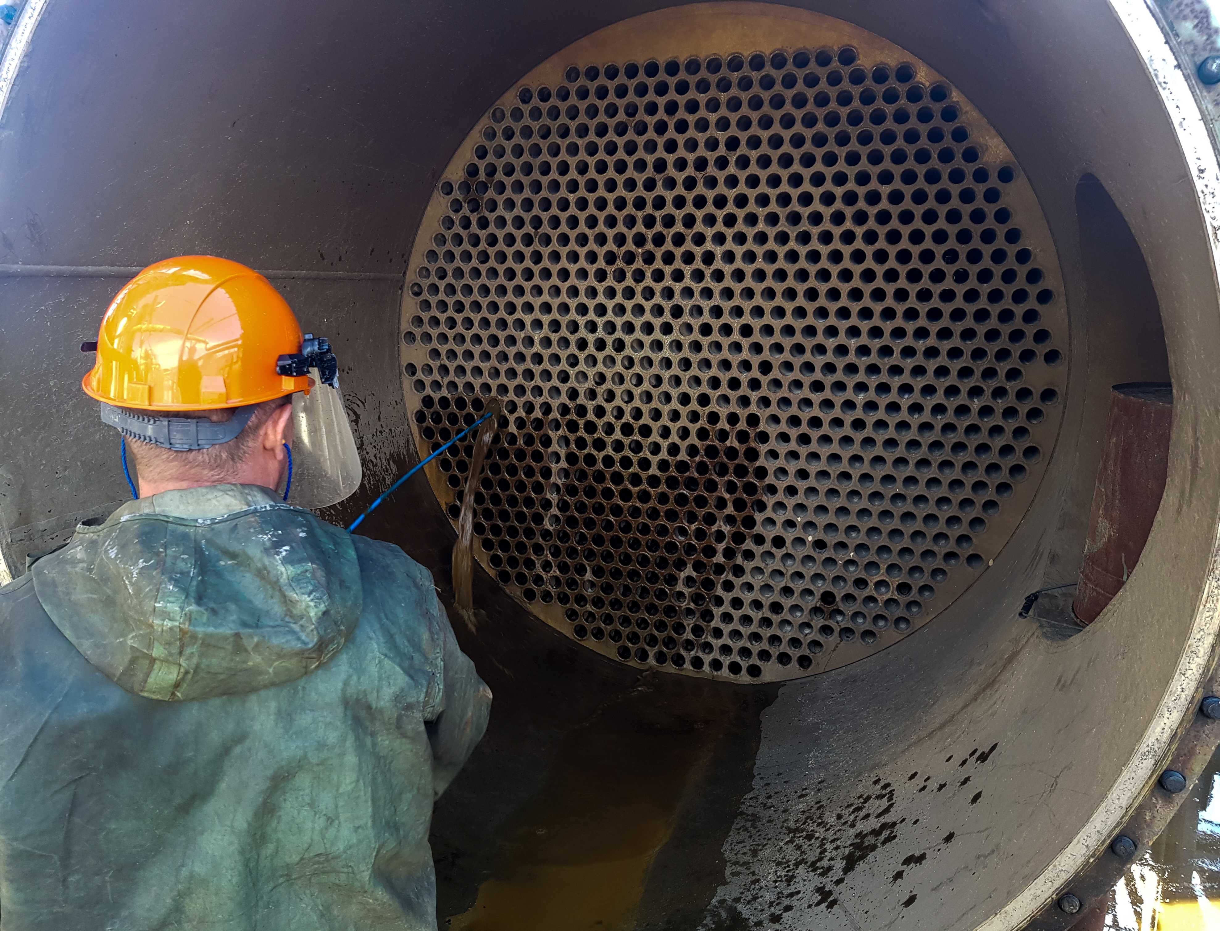 Industrial cleaner cleaning inside of silo with hose