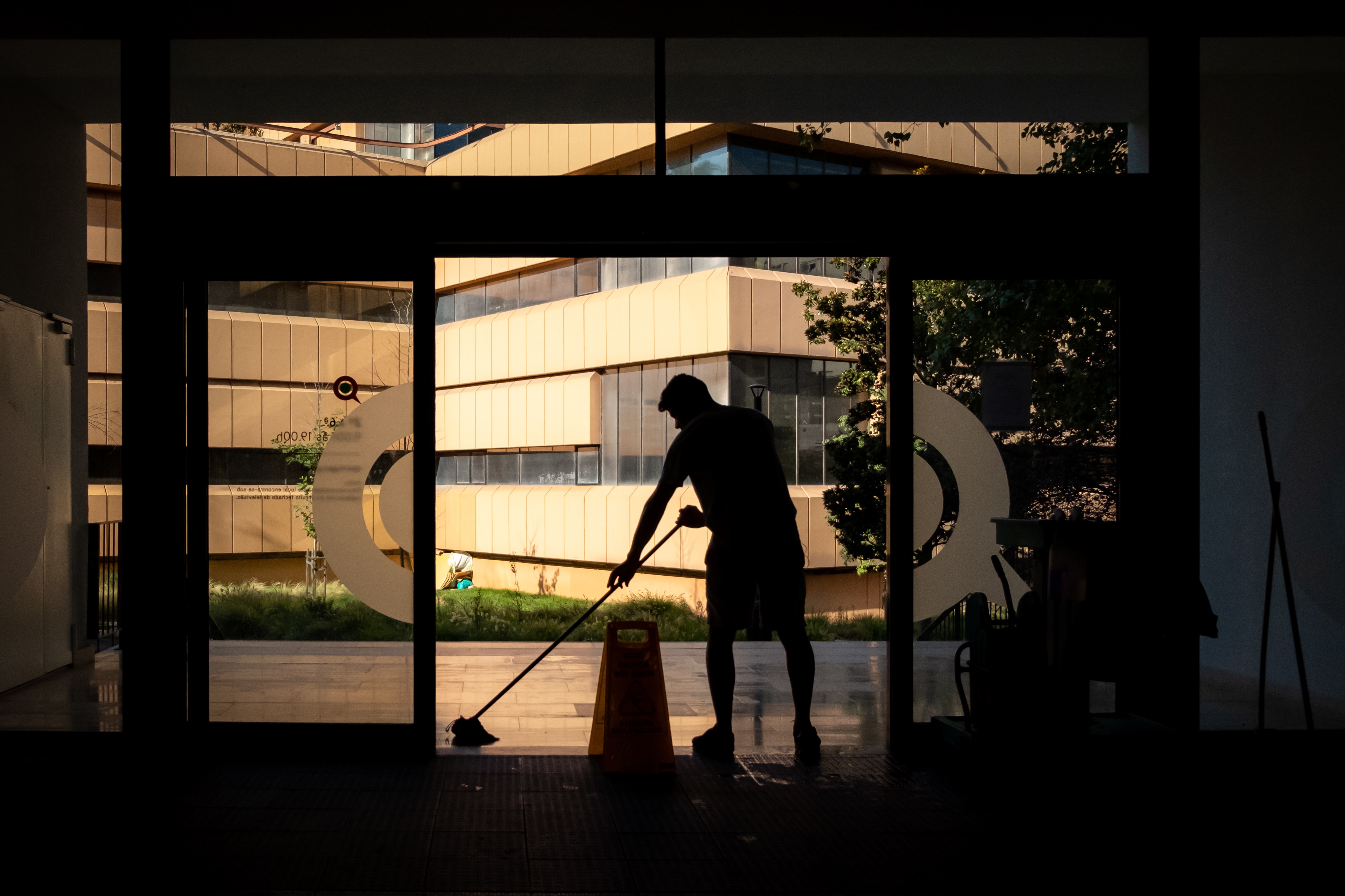 EVS technician cleaning the entrance to a hospital 