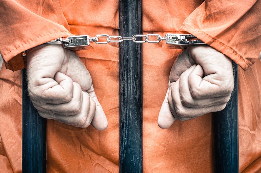 bigstock-Handcuffed-Hands-Of-A-Prisoner-102543272.jpg